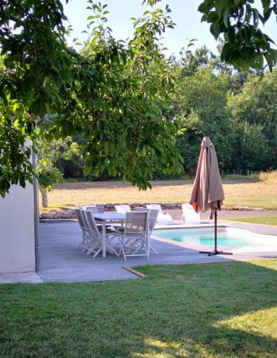 Gîte 2, table et parasol au bord de la piscine